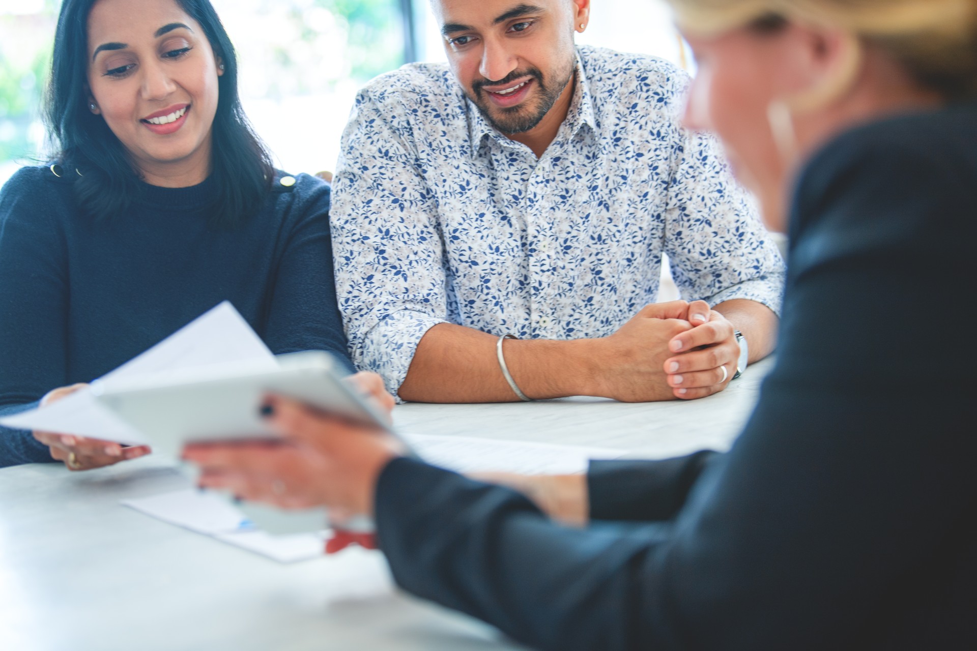 Mature couple meeting with financial advisor or real estate agent at home.